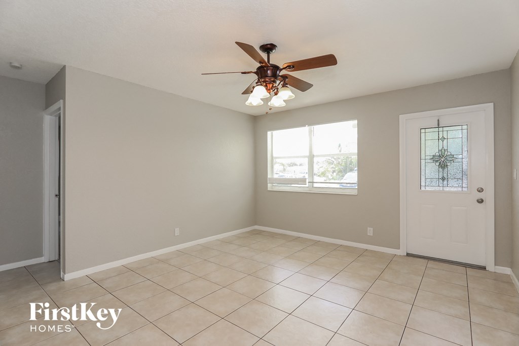 a clean and empty living room with a ceiling fan