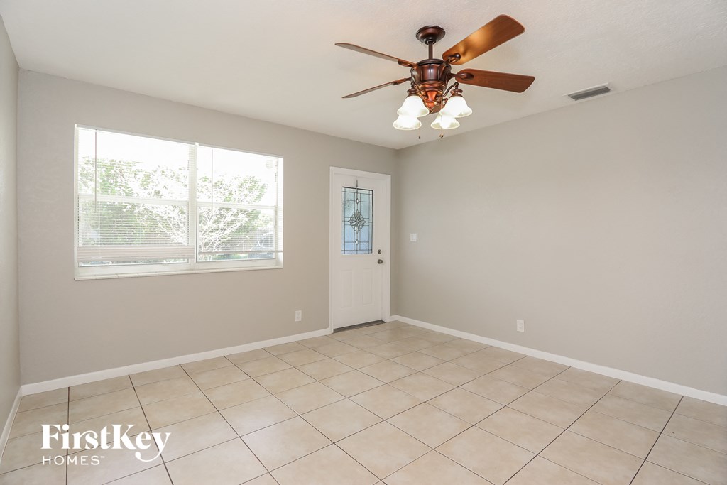 a living room with a ceiling fan and a window