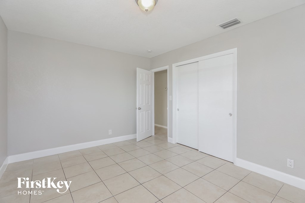 a master bedroom with a tiled floor and a closet