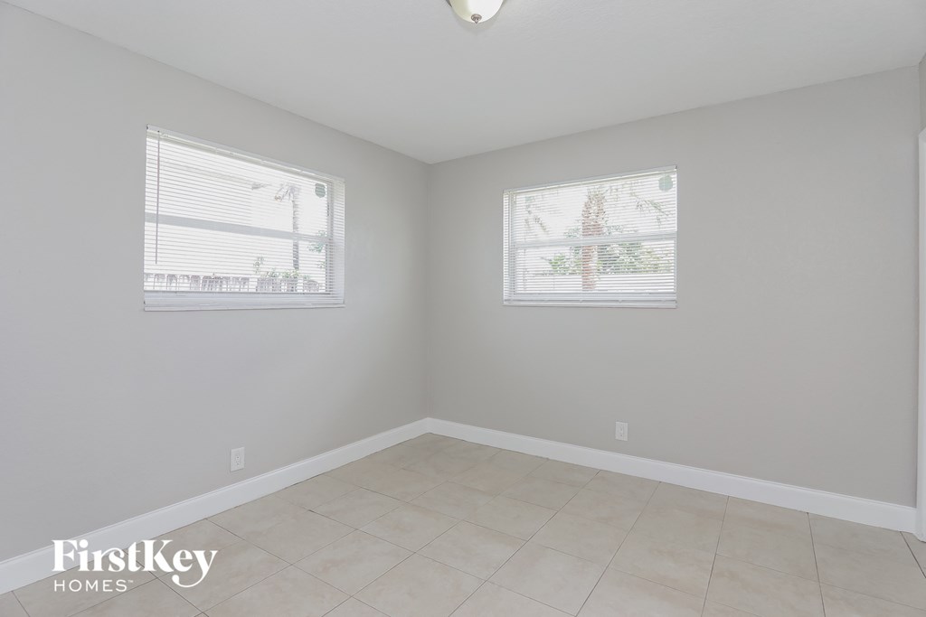 a room with a tiled floor and two windows