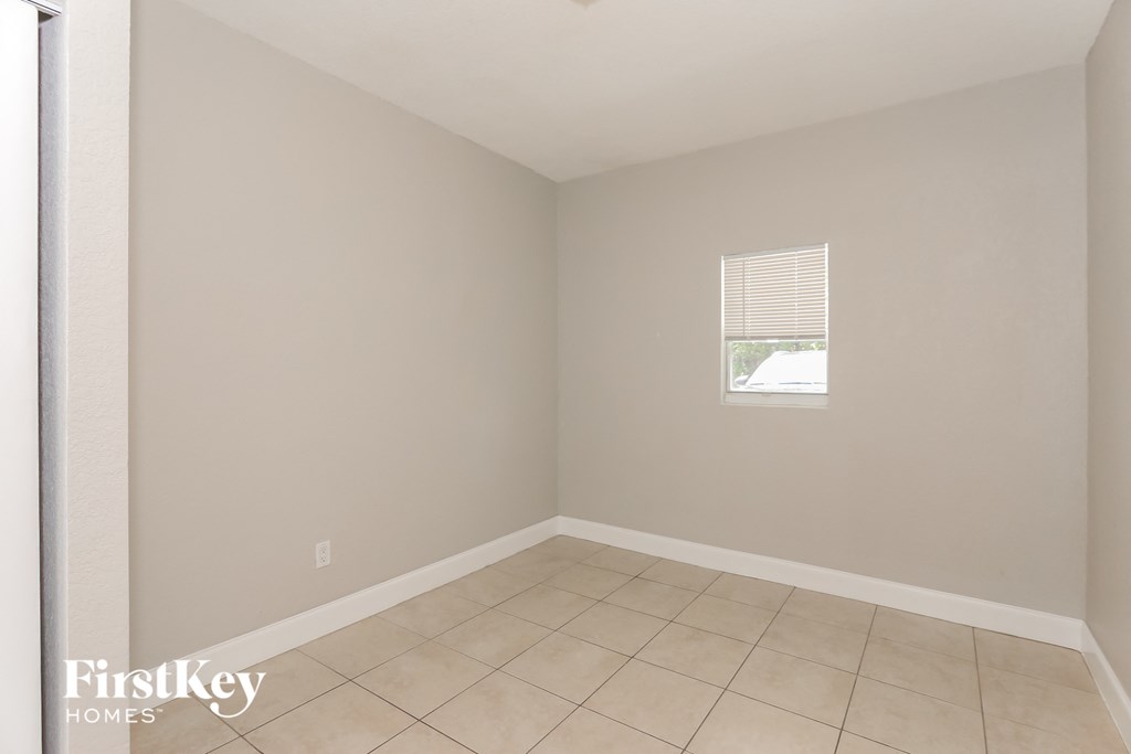 an empty room with a tiled floor and a window