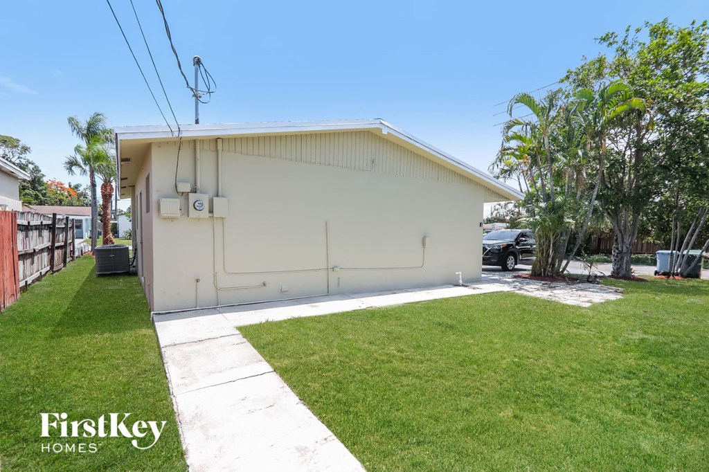 a small white house with a lawn and grass