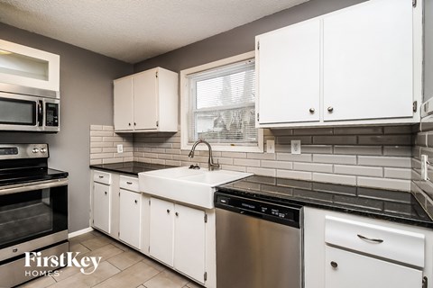 A kitchen with white cabinets and a stainless steel dishwasher.