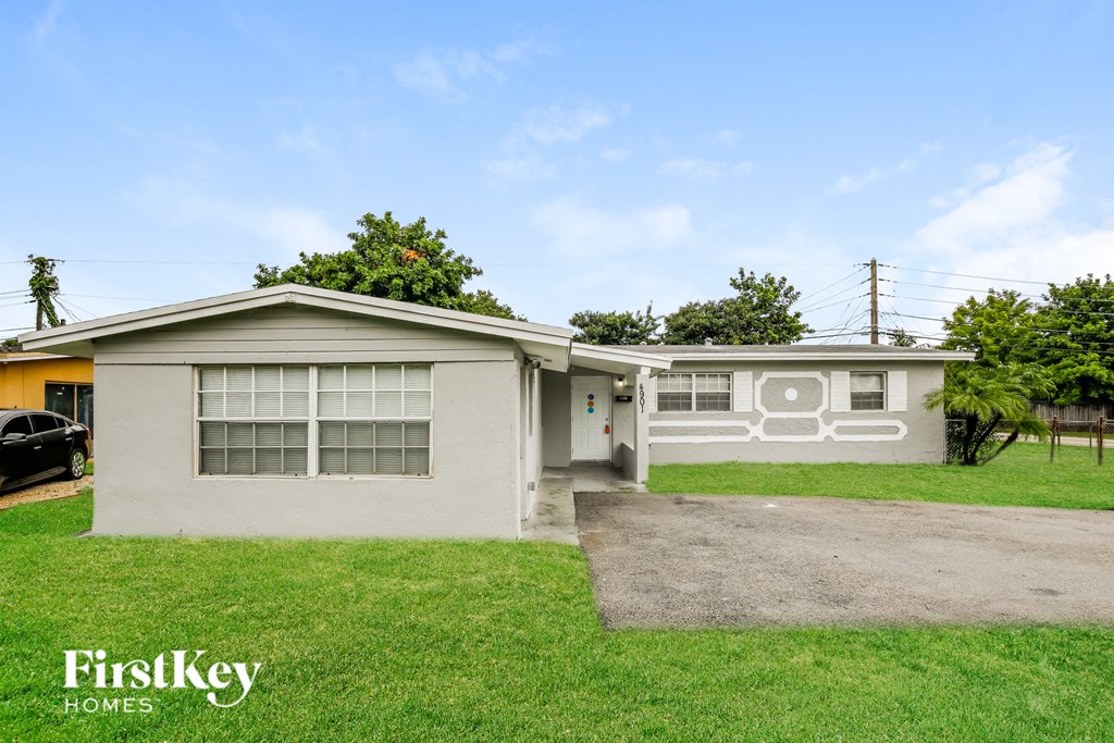 the front of a house with grass and a driveway