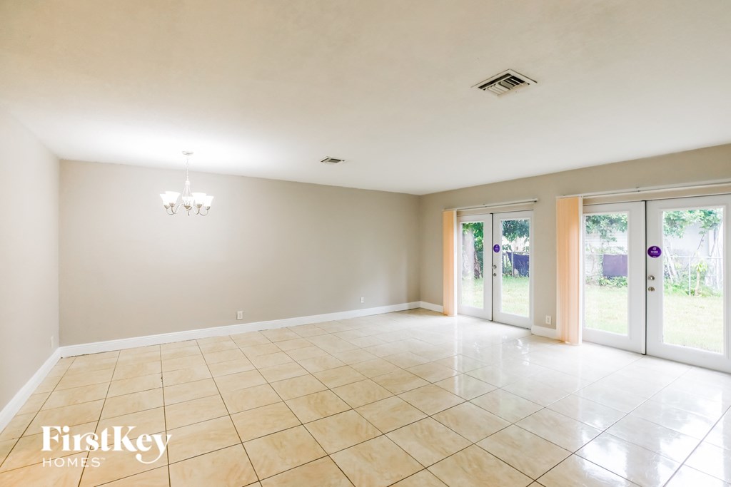 an empty living room with sliding glass doors to the patio