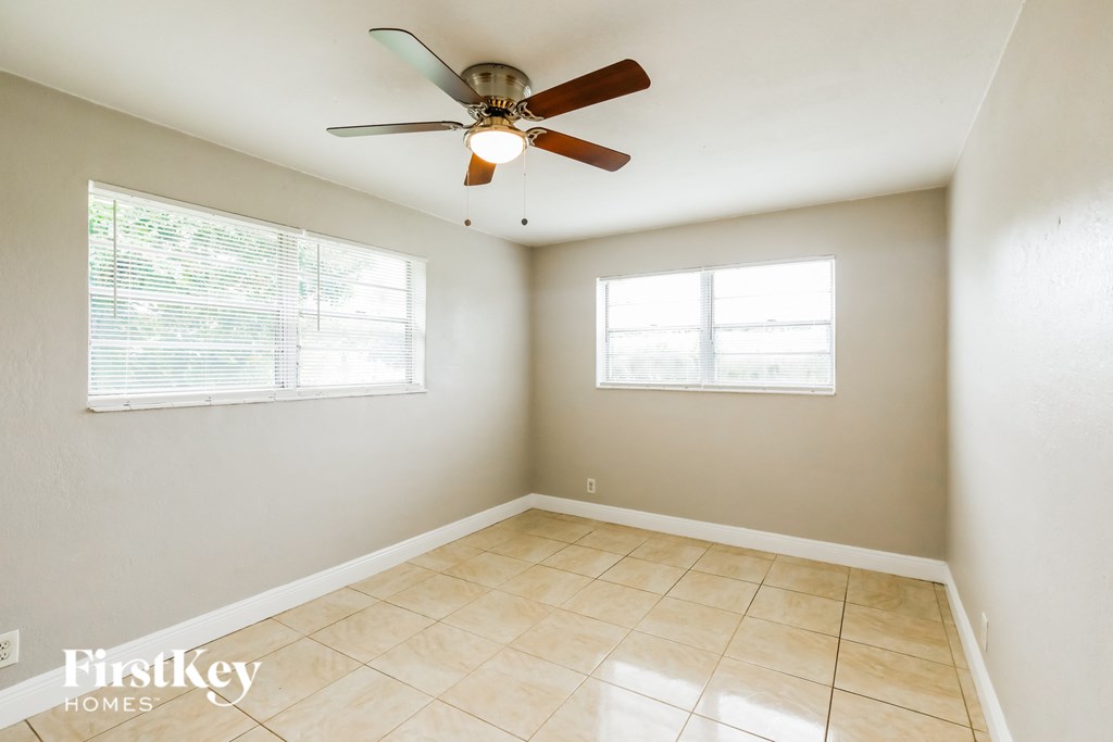 an empty room with a ceiling fan and a window
