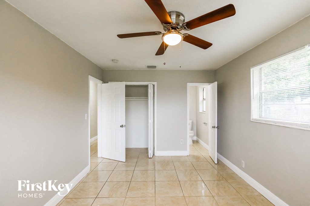 a hallway with a ceiling fan and a door to a bathroom