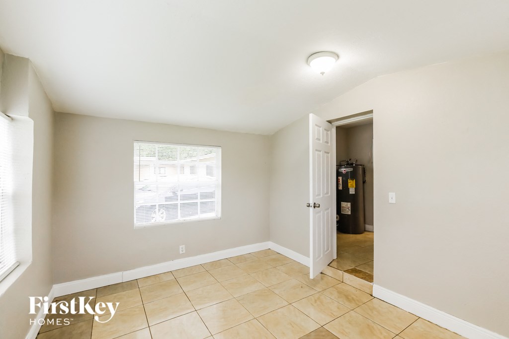 the living room and entryway of a home with tiled floors and a window