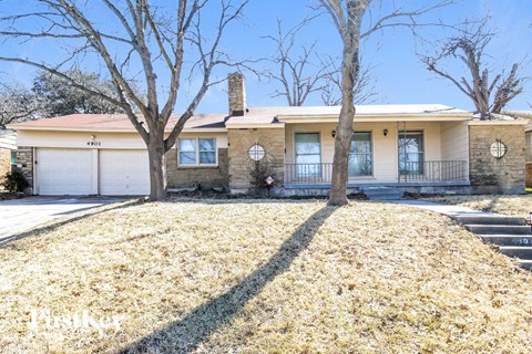 the front of a house with two trees and a yard