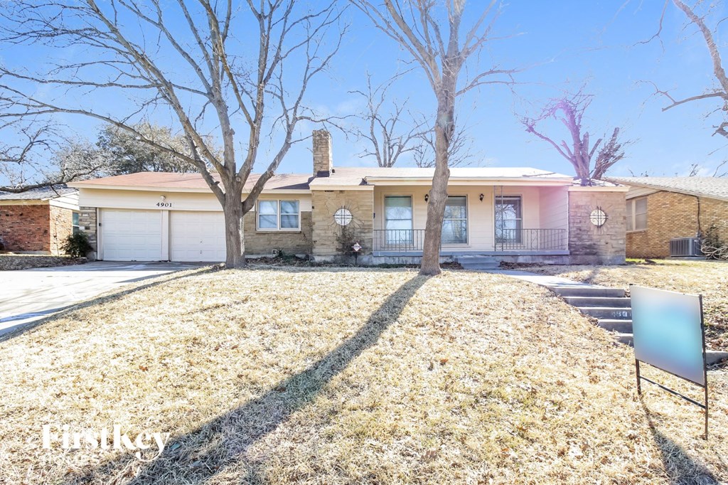 a house with a yard and a sign in front of it