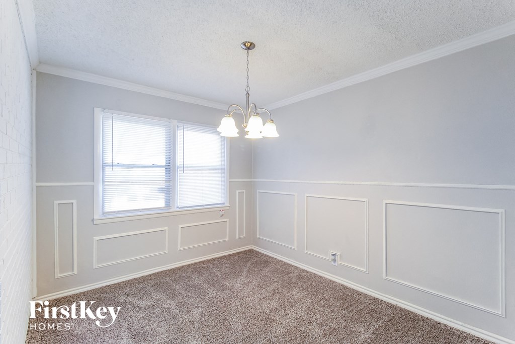 a dining room with white walls and a window