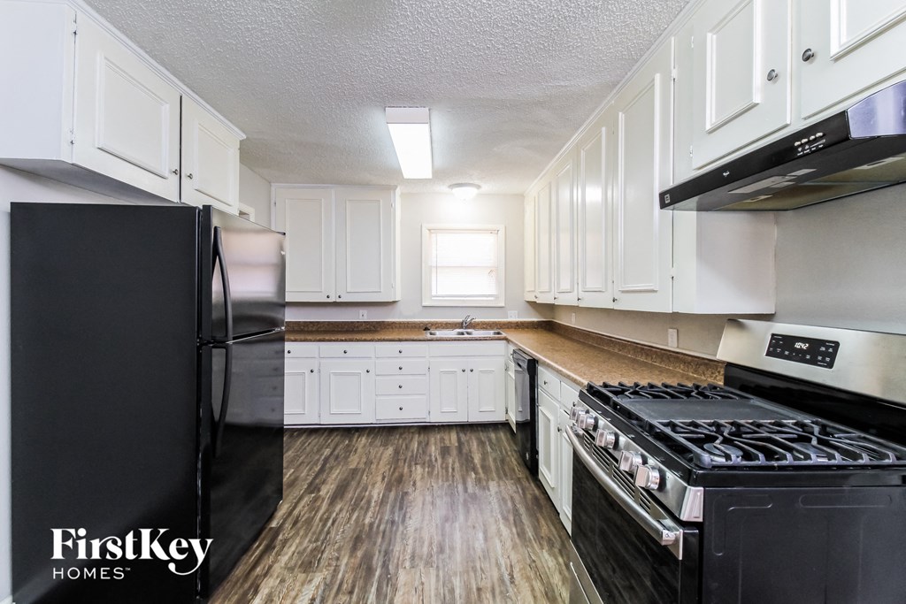 a kitchen with white cabinets and a stove and refrigerator