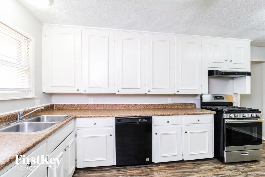 a white kitchen with white cabinets and a counter top
