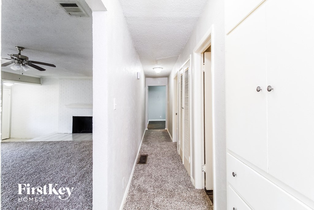 a hallway with a white closet and a ceiling fan