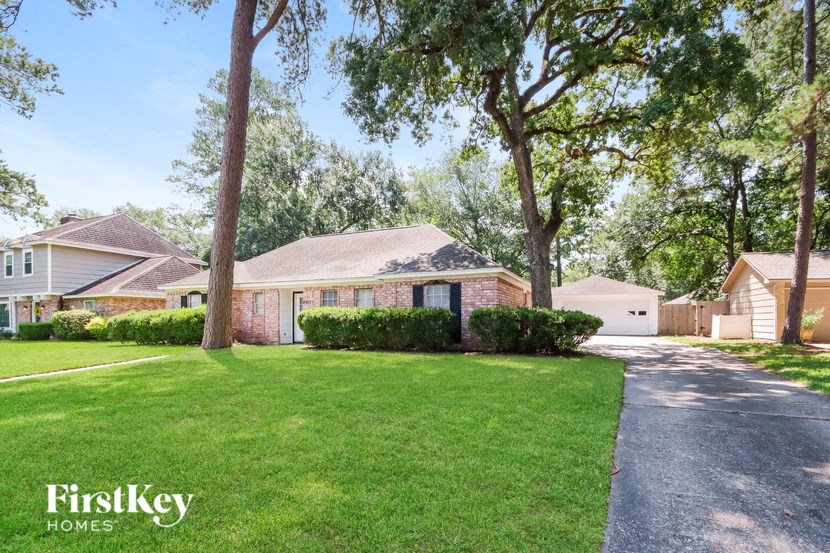a house with a lawn and trees in front of it