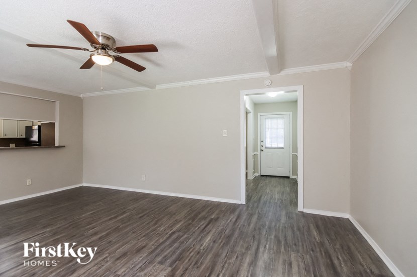 the living room of an empty house with a ceiling fan