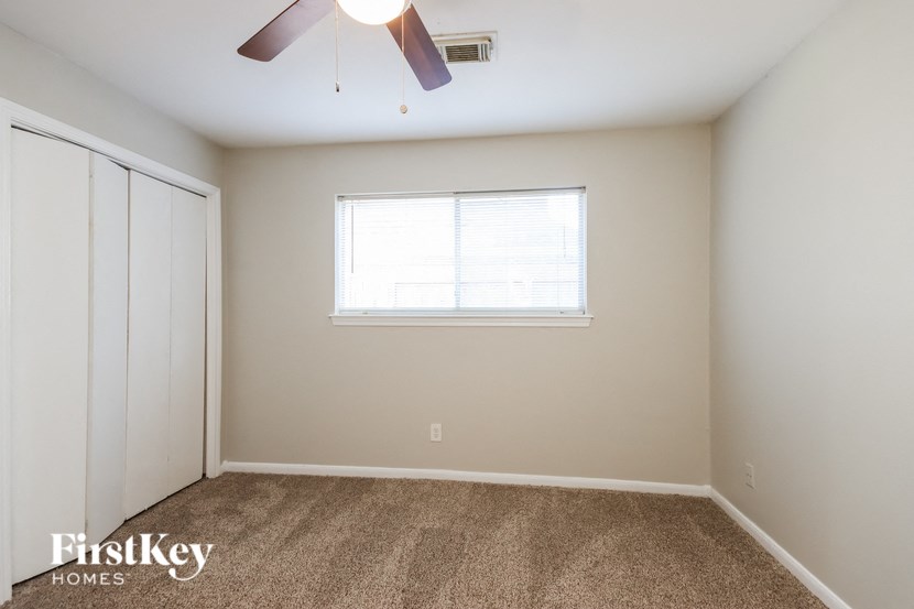 a bedroom with a ceiling fan and a window
