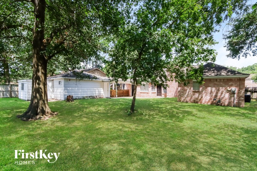 a backyard with a tree and a brick house