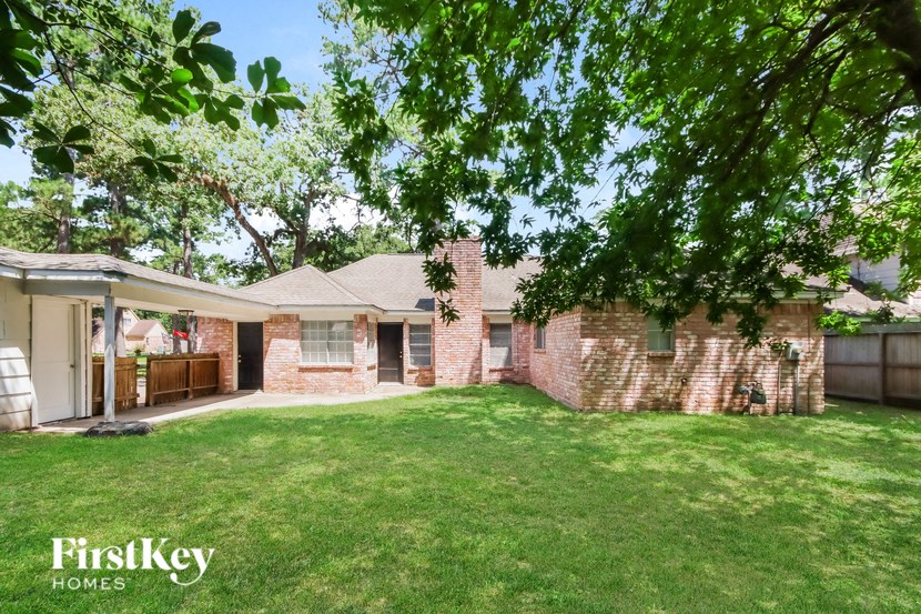 a brick house with a grass yard and a patio
