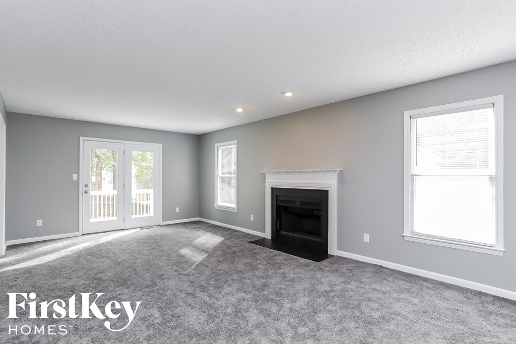 a living room with a fireplace and a carpeted floor