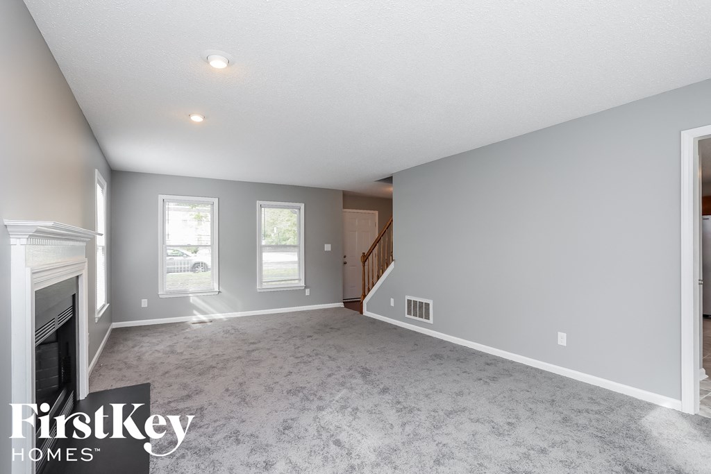 a living room with a fireplace and a carpeted floor