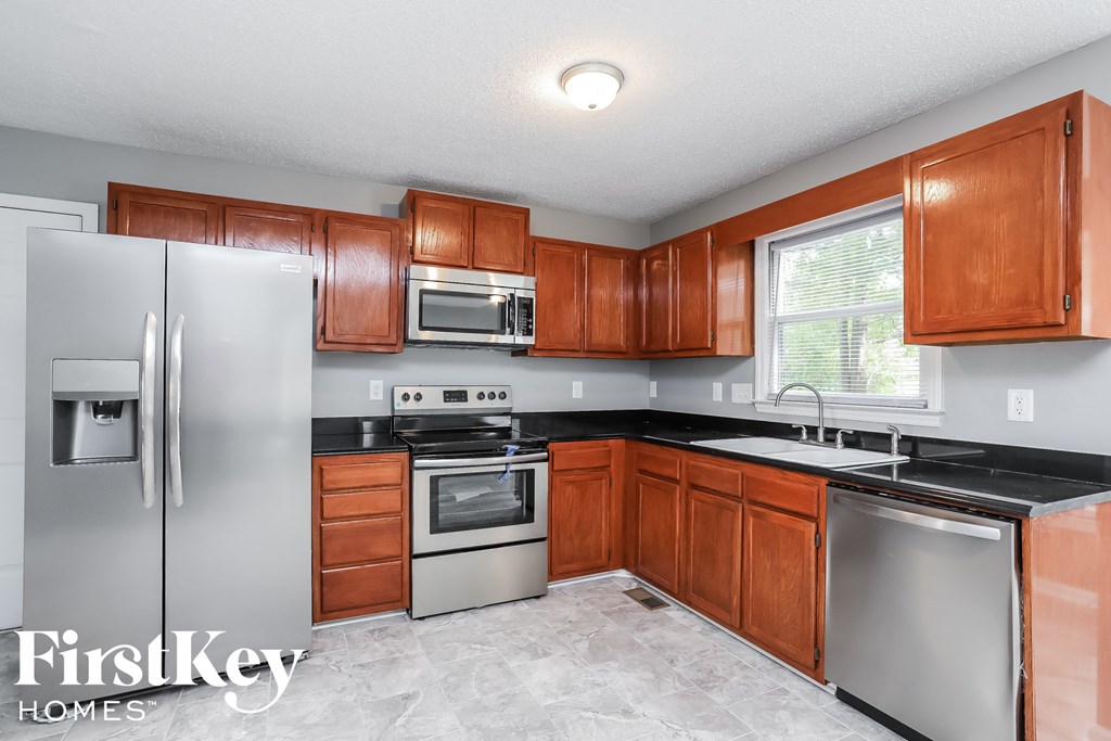a kitchen with wooden cabinets and stainless steel appliances
