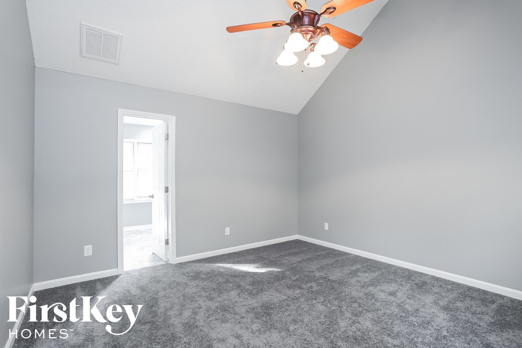 a bedroom with a ceiling fan and a carpeted floor