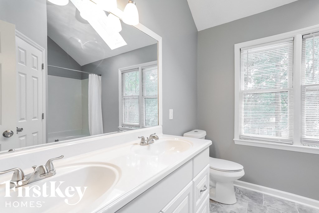 a bathroom with a large mirror and a sink and a toilet