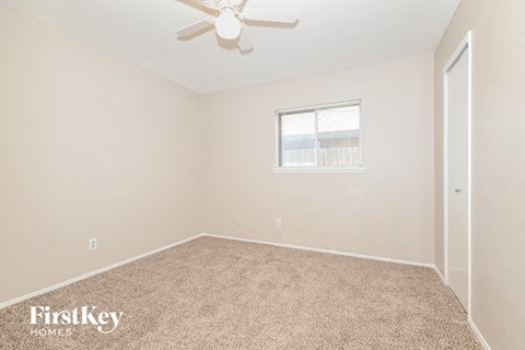 a bedroom with carpet and a ceiling fan