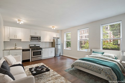 a bedroom with a couch and a bed and a kitchen