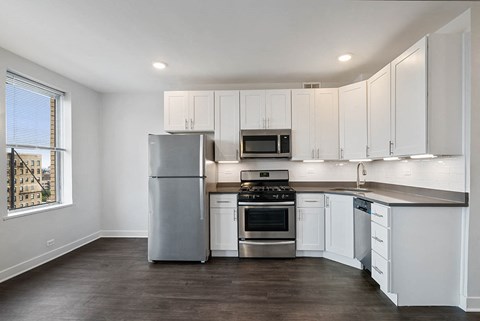 a kitchen with white cabinets and stainless steel appliances