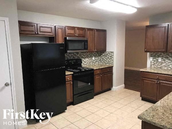 a kitchen with black appliances and wooden cabinets