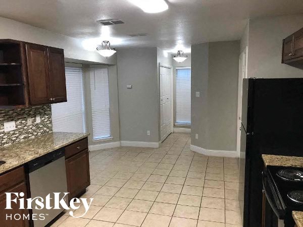 a kitchen with a black refrigerator and a sink