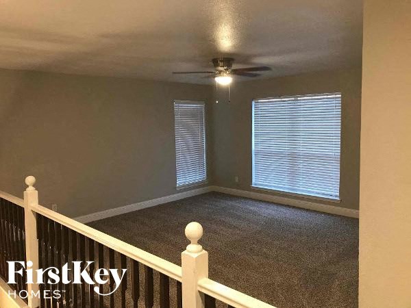 a empty room with a ceiling fan and a window