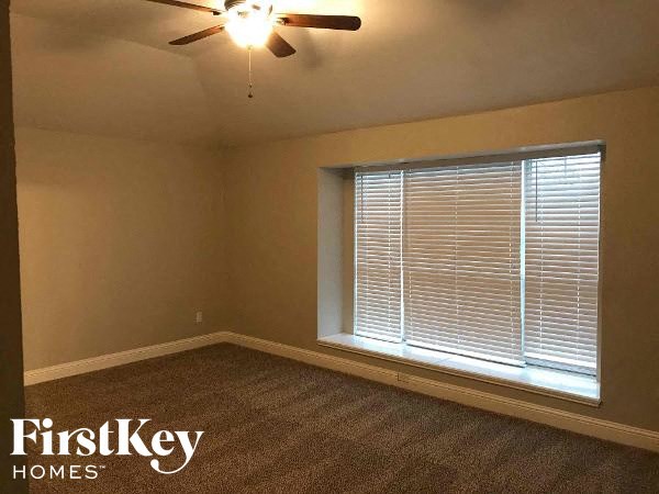 an empty room with a window and a ceiling fan