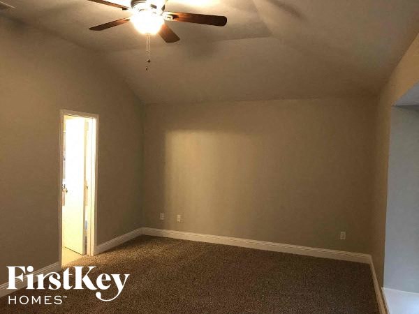 a empty room with a ceiling fan and a door