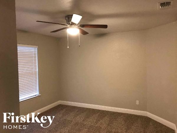 an empty room with a ceiling fan and a window