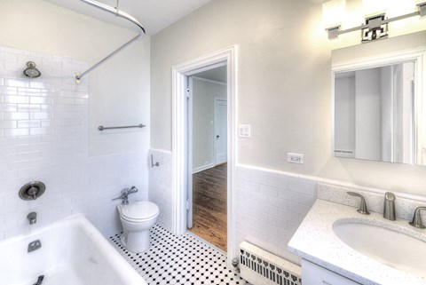 a bathroom with a toilet sink and tub and a mirror