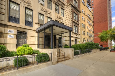 a building with stairs and a sidewalk in front of it