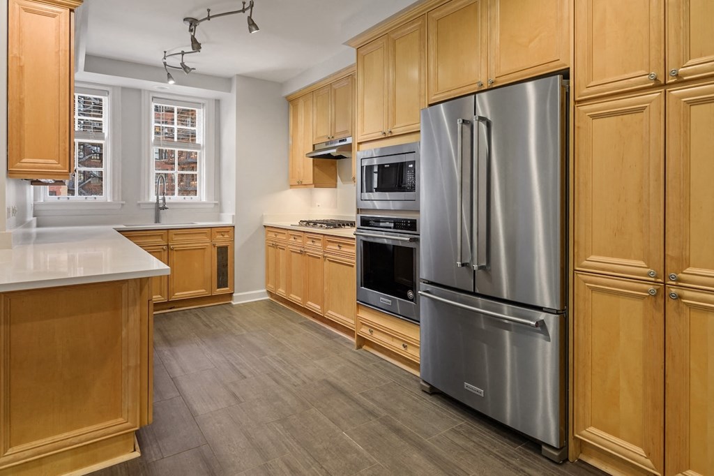 a kitchen with wooden cabinets and stainless steel appliances