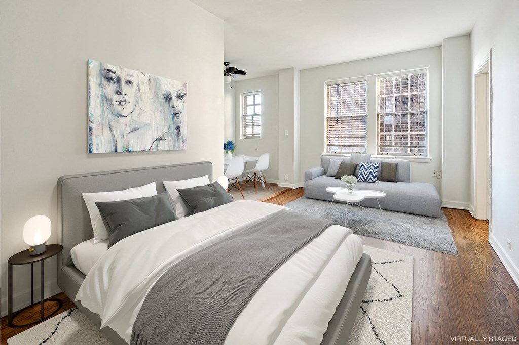 a bedroom with a bed and a couch and a window