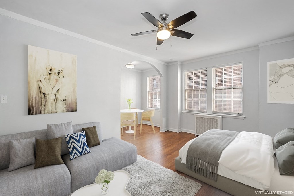 a living room with a bed and a ceiling fan