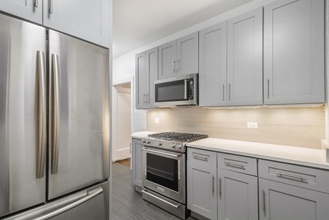 a kitchen with white cabinets and stainless steel appliances