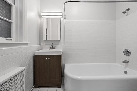 a white bathroom with a tub and a sink