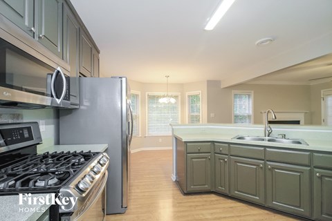 A kitchen with a stove top oven and a refrigerator.
