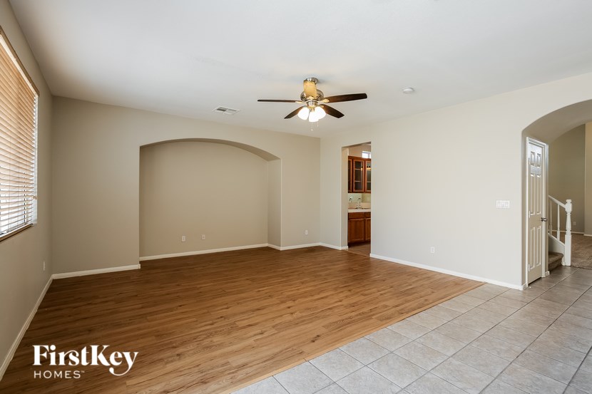 A spacious room with wooden flooring and a ceiling fan.