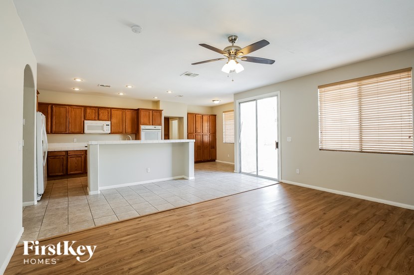 A spacious living room with wooden floors and a ceiling fan.
