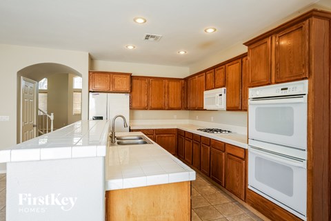 A kitchen with wooden cabinets and a white counter top.