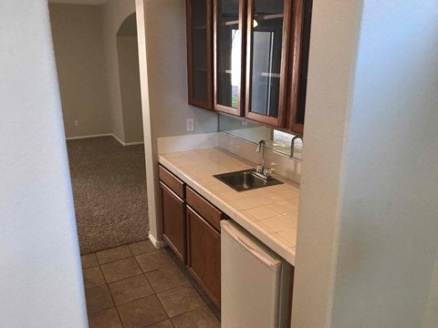 A kitchen with brown cabinets and a white counter.