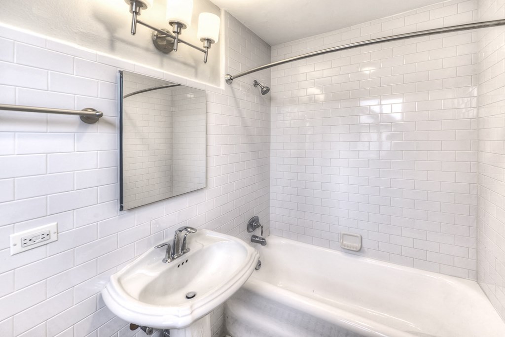 a bathroom with a sink and a tub and a mirror